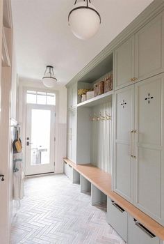 an empty room with many cabinets and shelves on the wall, along with a door leading to another room