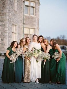 a group of women standing next to each other in front of a tall brick building