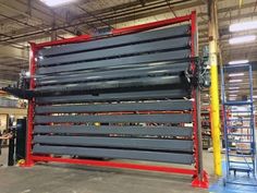 a large metal structure in a warehouse with people working on it's sides and two men standing next to it