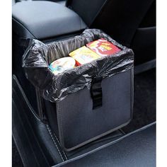 the back seat of a car is covered with black plastic and has two drinks in it