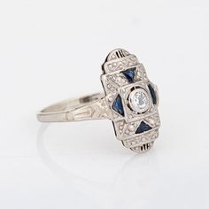 Finely detailed vintage Art Deco diamond & sapphire ring (circa 1920s to 1930s) crafted in 14k white gold.   One estimated 0.10 carat old European cut diamonds is estimated at J-K colour and I1 clarity. Four sapphires (lab) total an estimated 0.15 carats.    The stylish Art Deco era ring is set with an old European cut diamond to the centre, flanked with triangular cut sapphires. The small plaque ring is great for day or evening wear. The ring has a low profile and rises 5mm from the finger (0.1 Art Deco Diamond Sapphire Ring, Diamond Sapphire Ring, Art Deco Diamond Ring, Deco Diamond Ring, Art Deco Diamond Rings, Stylish Art, Sapphire Diamond Ring, Band Jewelry, European Cut Diamonds