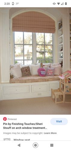 a window seat in front of a window filled with pillows and other items on it