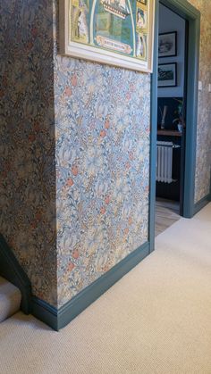 the hallway is decorated with blue and orange wallpaper, along with carpeted stairs