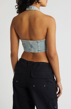 Amp up your edge in this cropped halter top designed in light-wash denim with a zip closure and corset-inspired details. 8 1/2" center front length (size Medium) Front zip closure Halter neck 95% cotton, 4% polyester, 1% spandex Machine wash, line dry Imported Fitted Cropped Denim Tube Top, Trendy Denim Bandeau Crop Top, Cropped Denim Corset For Summer, Fitted Denim Blue Bandeau Denim Top, Fitted Denim Blue Bandeau Top, Fitted Washed Blue Cropped Denim Top, Fitted Strapless Denim Crop Top, Strapless Fitted Denim Crop Top, Spring Cropped Denim Corset