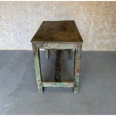 an old wooden table sitting in front of a wall