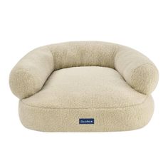 a dog bed that is made out of sheepskin and has a blue logo on the front