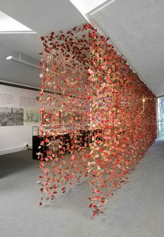 a room filled with lots of red and yellow confetti hanging from the ceiling