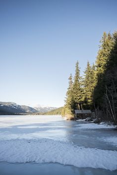 an icy lake surrounded by trees and mountains