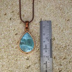 The most beautiful gemstone found only in the Dominican Republic, Larimar is a stone of coolness and calm, much like the native waters it resembles. Larimar is a powerful healer! It can help with panic attacks, anger, fear and other stress-related issues. Secure this unique and beautiful one-of-a-kind Larimar pendant around your neck and breathe in the calm of the Caribbean ocean! Includes a 22" copper-plated snake chain (electroplated brass in antique copper color) Lead-free; nickel-safe Bezel-set in copper Pendant is approximately 1.65”H (42.1mm) x .86”W (21.9mm) Comes in our exclusive luxury gift box Source: Dominican Republic Any visible imperfections and/or cracks are due to natural formation Product color may slightly vary due to photographic lighting sources! Disclaimer: Crystals sh Caribbean Ocean, Orange Stone, Larimar Pendant, Book Jewelry, The Dominican Republic, Copper Pendant, Clear Stone, Purple Stones, Luxury Gift Box