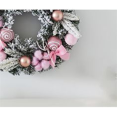 a pink and white christmas wreath with ornaments