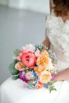 a bride holding a bouquet of flowers on her wedding day