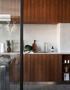 a kitchen with wooden cabinets and marble counter tops