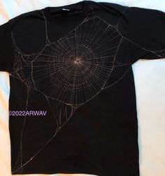 a black t - shirt with a spider web on it