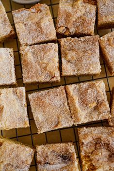 several pieces of cake sitting on top of a cooling rack with powdered sugar over them