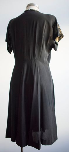 "ABOUT: Gorgeous black 1940s cocktail dress with black lace collar and bodice with scalloped, elaborately beaded accents below. Lovely tailoring with pleats at the side of the skirt. This dress zips up the side. TAG: n/a SIZE: n/a FITS LIKE: medium MEASUREMENTS- Taken with garment laying flat, in inches, not doubled: Shoulder: 18\" Bust: 21\" Waist: 17\" Bodice length: 18\" Overall length from shoulder down: 40\" CONDITION: In great condition considering age. No beads look missing at all, what a Black 1920s Style Dress For Vintage Events, Classic Black Dress For Vintage Fashion, Classic Black Dress For Vintage Events, 1950s Style Black Dress For Vintage Events, Black Short Sleeve Dress For Vintage Fashion, 1920s Black Cocktail Dress, 1940s Cocktail Dress, 1950s Style Black Vintage Dress, Black 1950s Style Vintage Evening Dress