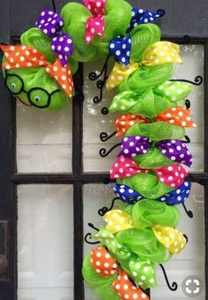 a colorful wreath with glasses and polka dots is hanging on the front door, decorated with ribbon