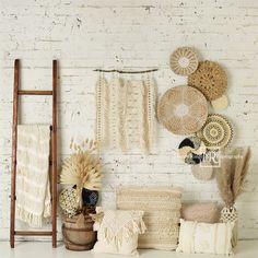 a white brick wall filled with lots of different types of knitted items and decor