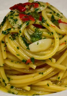 a close up of a plate of food with noodles and vegetables on it, garnished with parsley