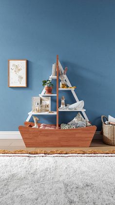 a small wooden boat sitting on top of a rug in front of a blue wall