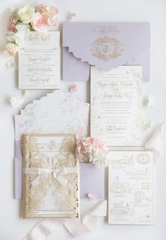 the wedding stationery is laid out on top of each other, with pink and white flowers