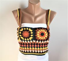 a crocheted top on a mannequin with a white shirt underneath it