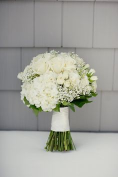 a bridal bouquet with white roses and baby's breath