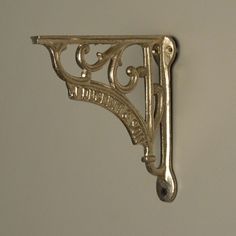 an ornate metal shelf bracket on the wall