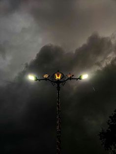 a street light on a cloudy night with the sky in the background