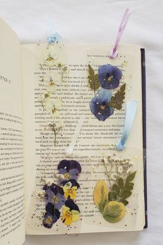 an open book with pressed flowers on it