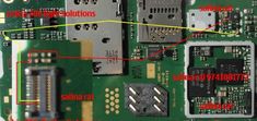 the motherboard and components of an electronic device are labeled in red, yellow, and green