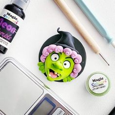 an assortment of crafting supplies on top of a white table with a laptop and pen