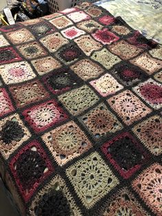 a crocheted blanket on top of a bed in a room with other items