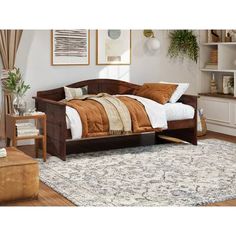 a bed sitting on top of a wooden floor next to a white and brown rug