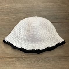 a white and black hat sitting on top of a wooden floor