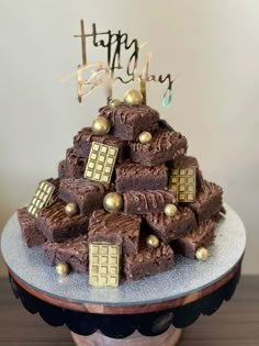 a birthday cake made to look like a tardist tower with chocolate frosting and gold decorations