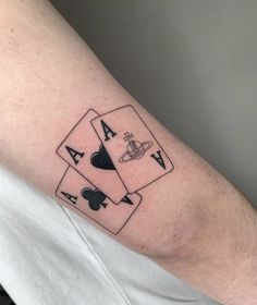 a man's arm with three playing cards tattoo on it