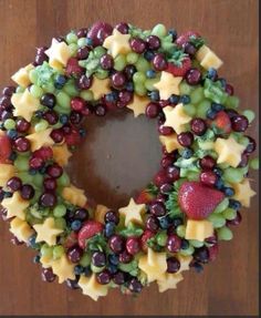 a wreath made out of grapes, strawberries and cheese