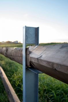 a close up of a wooden fence with grass in the background