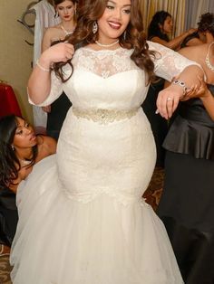 a woman in a wedding dress is posing for the camera with other women around her