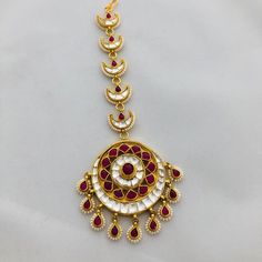 Sabyasachi Kundan Mang Tika/Ruby Mang Tikka/Pearl Maang Tika/Ruby Pearl Maang Tika/Kundan Maang Tikka/Kundan Big Mang Tikka/Bridal Jewelry Features: Length: 5 Inches 22 Carat Gold polish Jadau Ruby Crystals, Kundan and Pearl work Suitable for any Indian Traditional Attire FREE SHIPPING All our jewelry pictures are taken in natural light with no filters and enhancements. To stay updated on latest designs Follow Us on: Website: www.aryafashions.com Facebook: www.facebook.com/shoparyafashions Pinte Festive Kundan Tikka For Rituals, Traditional Meenakari Tikka For Rituals, Festive Cutdana Tikka, Kundan Tikka For Diwali Rituals, Chandbali Cutdana Tikka For Rituals, Bollywood Style Tikka For Diwali Rituals, Bollywood Style Festive Tikka For Rituals, Bollywood Style Festive Ritual Tikka, Festive Cutdana Tikka For Festivals