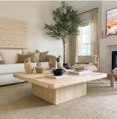 a living room filled with furniture and a tree in the middle of the room on top of a coffee table