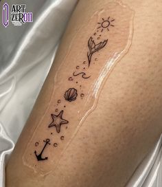 a woman's arm with an anchor, starfish and seaweed tattoo on it