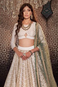 Ivory can can attached lehenga with all over embroidered floral jaal motifs with sequin work. Comes with padded cut-out blouse and dupatta.
Components: 3
Pattern: Embroidered
Type Of Work: Sequin,Thread
Neckline: Round
Sleeve Type: Three quarter
Fabric: Raw silk
Color: Ivory
Other Details: 
Length: Lehenga: 44 inches
Model Height: 5ft 8inches wearing size XS
Closure: Blouse: Back hook, zip
Note: Neckpiece worn by the model is not for sale
Occasion: Sangeet,Cocktail - Aza Fashions Embroidered Silk, Raw Silk, Indian Wear, Three Quarter, Aza Fashion, Lehenga, Cut Out, Types Of Sleeves, Silk