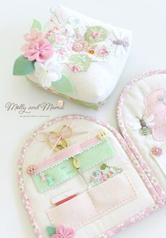 two handmade purses are sitting on a white surface with pink flowers and green leaves