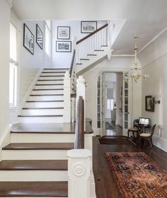 a staircase leading up to the second floor in a house with white walls and wood floors