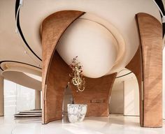 the interior of a modern house with wood and glass accents on the ceiling, chandelier in the center