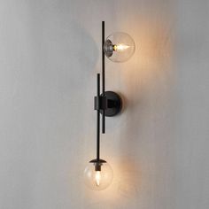 two light fixtures on the wall with one bulb turned off and another is lit up