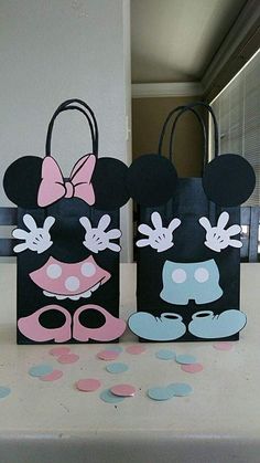 two minnie mouse bags sitting on top of a table