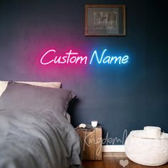 a neon sign that says custom name on the wall above a bed