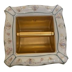 a gold and white porcelain tissue dispenser